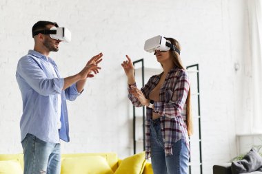 Genç mutlu çift, VR gözlükleriyle eğleniyor.