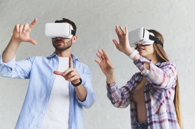 Genç mutlu çift, VR gözlükleriyle eğleniyor.