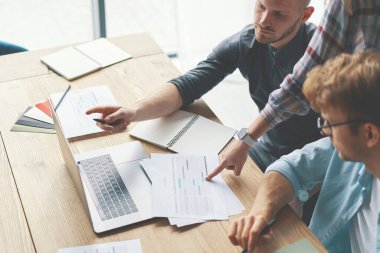 Bilgisayar dizüstü bilgisayarı ve grafik grafikleri ile birlikte çalışan veri analiz ekibinin kırpılmış resmi