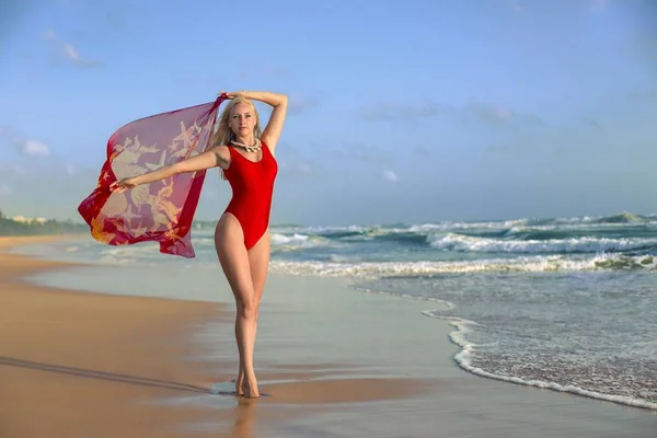 Женщина позирует с парео на пляже — стоковое фото