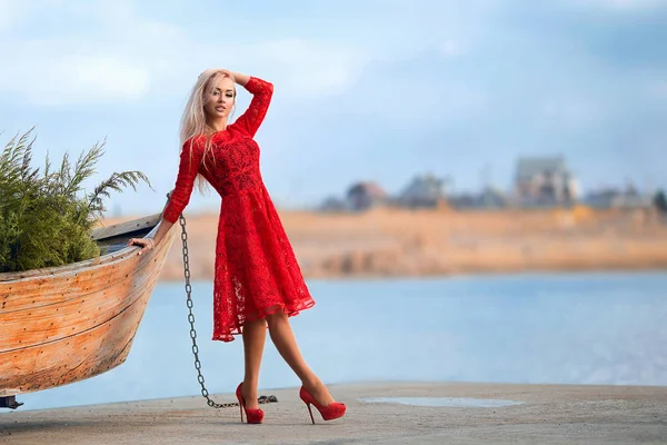 Mulher de vestido vermelho no cais do rio — Fotografia de Stock