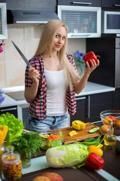 Donna che cucina insalata al tavolo della cucina — Foto Stock