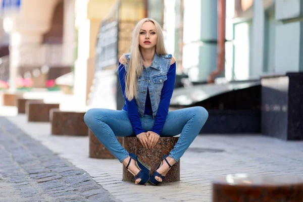 Mulher de jeans fantasia sentado ao ar livre . — Fotografia de Stock