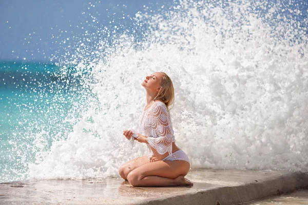 İskelede dev dalgaları ile oturan kadın. — Stok fotoğraf