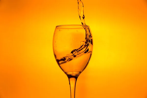 Ποτήρι κρασιού με πιτσίλισμα σταγόνες φρέσκου νερού — Φωτογραφία Αρχείου