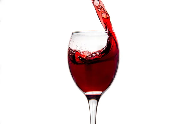 Wineglass with splashing drops of red wine — Stock Photo, Image