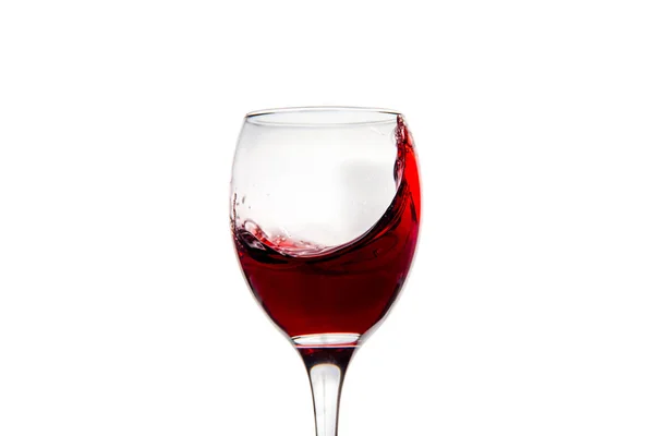 Wineglass with splashing drops of red wine — Stock Photo, Image