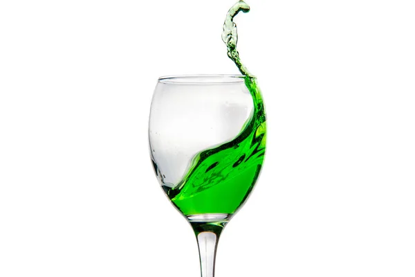 Винний келих з бризкими краплями зеленого алкогольного коктейлю — стокове фото