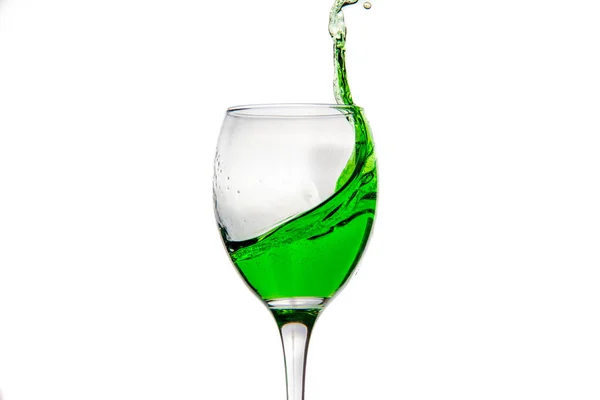 Ποτήρι κρασιού με πιτσίλισμα σταγόνες πράσινο οινόπνευμα κοκτέιλ — Φωτογραφία Αρχείου
