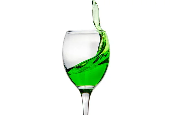 Винний келих з бризкими краплями зеленого алкогольного коктейлю — стокове фото