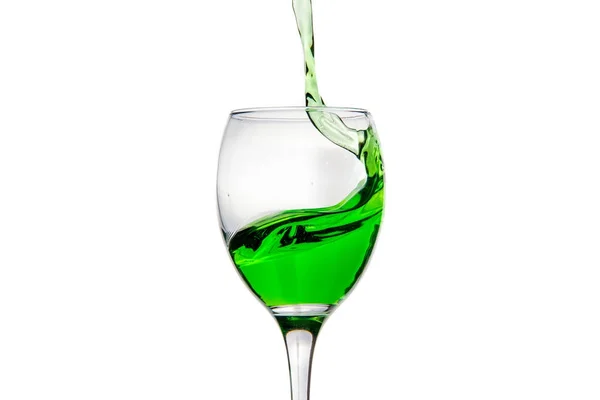 Wijnglas met spatten druppels groene alcohol cocktail — Stockfoto