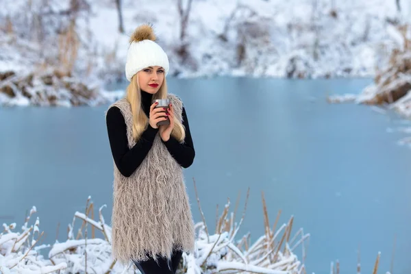 Beautiful blonde girl with hot drink in winter. — Stock Photo, Image