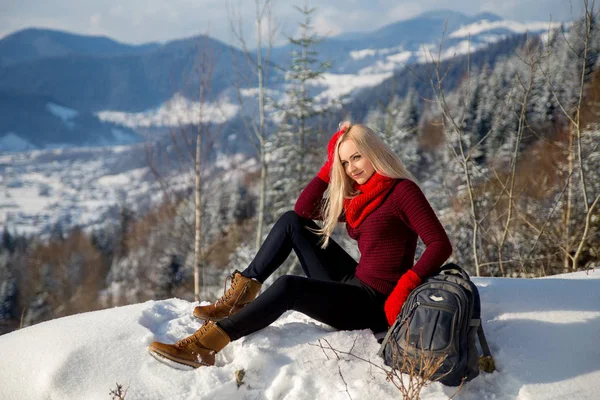 Beautiful blonde tourist girl sitting on the rock. — Stock Photo, Image