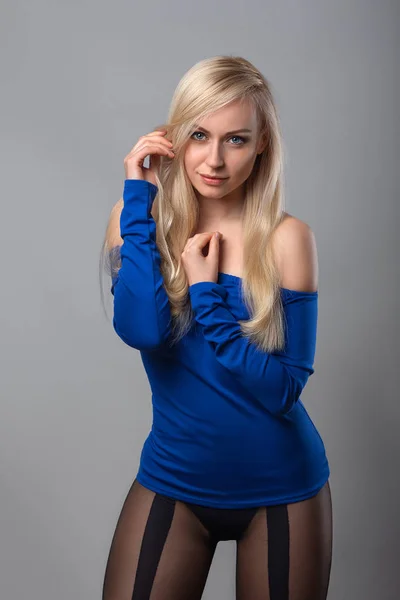 Женщина позирует в колготках и голубой блузке — стоковое фото