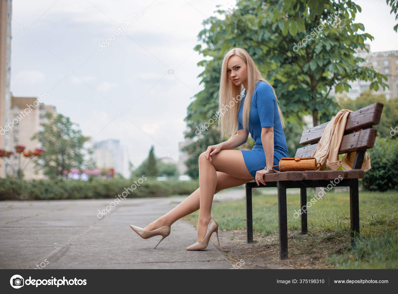 Sexy Female Legs. Fashion Long Legs Blonde Girl Sitting on Bench Stock  Photo