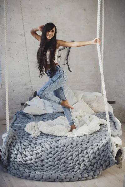 Ευτυχισμένος νεαρή γυναίκα που ποζάρει στο κρεβάτι — Φωτογραφία Αρχείου