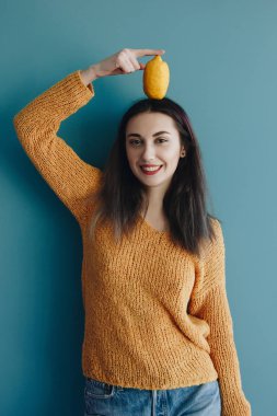 Kafasındaki limonlu gülümseyen genç kadın