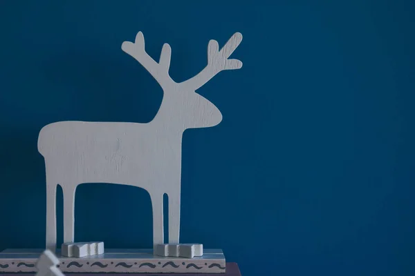Fondo azul de Navidad con ciervo de madera blanco — Foto de Stock