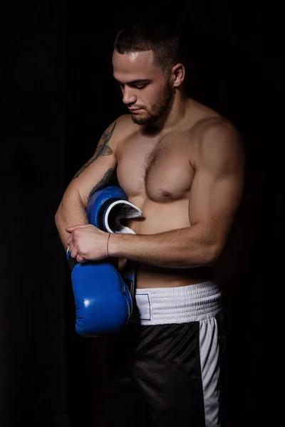 Boxer zieht blaue Boxhandschuhe an — Stockfoto