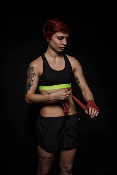 Mulher está enrolando as mãos com envoltórios de boxe vermelho — Fotografia de Stock