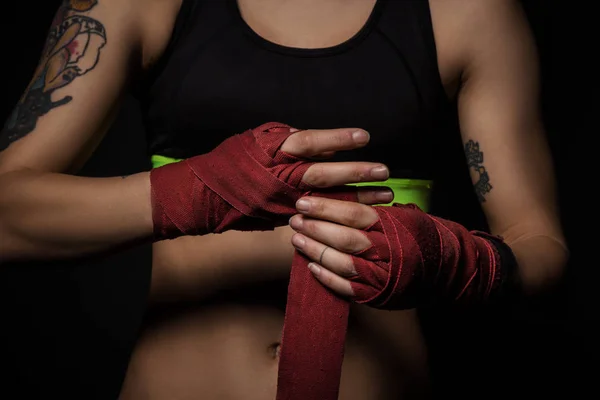 Primer plano de una mujer que envuelve las manos con envolturas de boxeo rojas — Foto de Stock