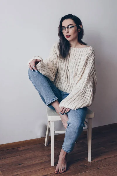 Genç kadın büyük boyutlu kazak ve anne kot pantolon