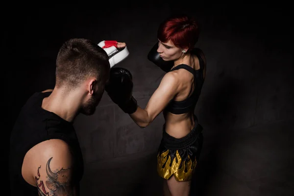Mulher boxeador bater luvas de treinamento realizada um treinador de boxe — Fotografia de Stock
