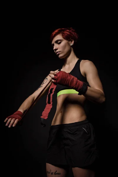 Mujer envolviendo las manos con envolturas de boxeo rojo — Foto de Stock