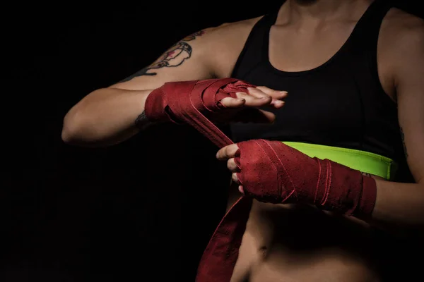Close-up de uma mulher envolvendo as mãos com envoltórios de boxe vermelho — Fotografia de Stock