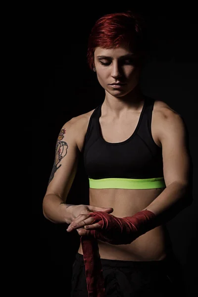 Mujer envolviendo las manos con envolturas de boxeo rojo — Foto de Stock