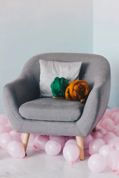 Оранжевый и зеленый шерстяной шар мериноса лежит на кресле — стоковое фото