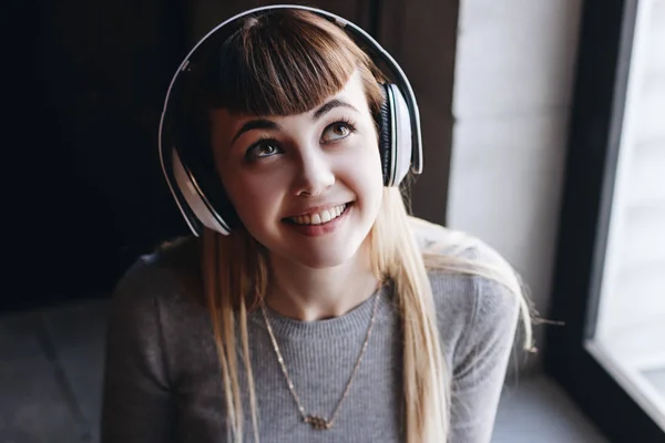 Güzel genç kadın gülümseyerek müzik dinlerken kulaklık