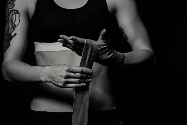 Close-up de uma mulher envolvendo as mãos com invólucros de boxe — Fotografia de Stock