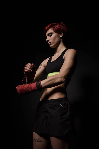 Mulher envolvendo mãos com envoltórios de boxe vermelho — Fotografia de Stock