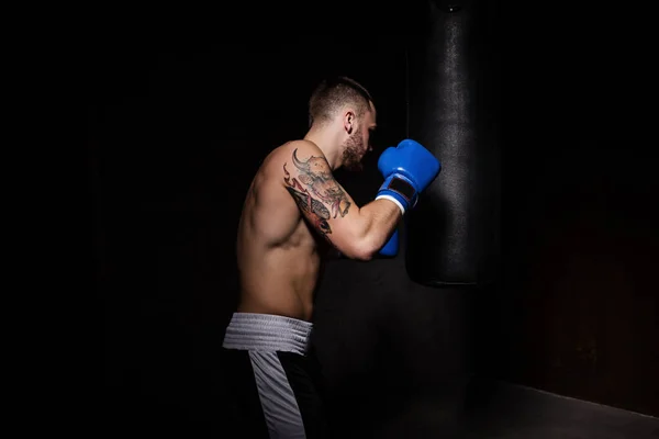 Atleta boxeador homem perfurando um saco de perfuração — Fotografia de Stock