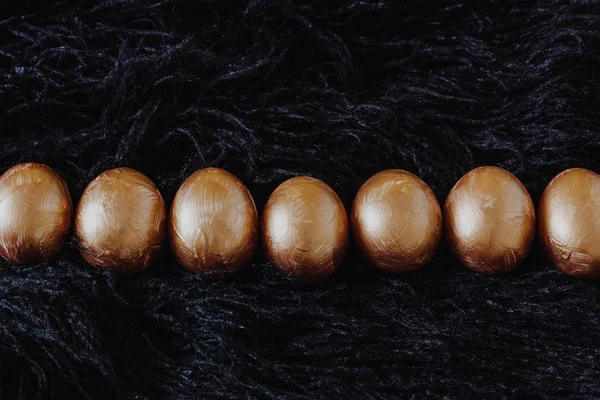 Baris telur Paskah emas pada hitam — Stok Foto