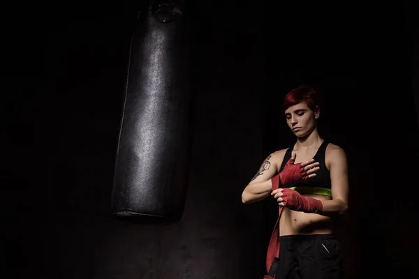 Mujer está envolviendo las manos con envolturas de boxeo rojo — Foto de Stock