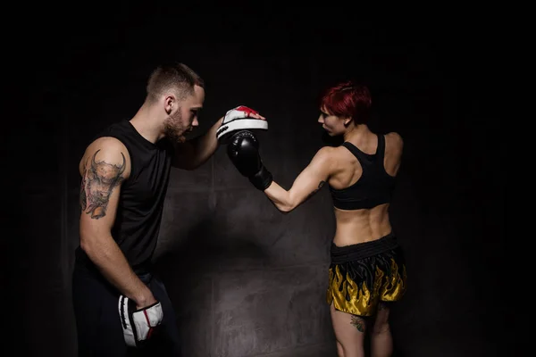 Mulher boxeador bater luvas de treinamento realizada um treinador de boxe — Fotografia de Stock