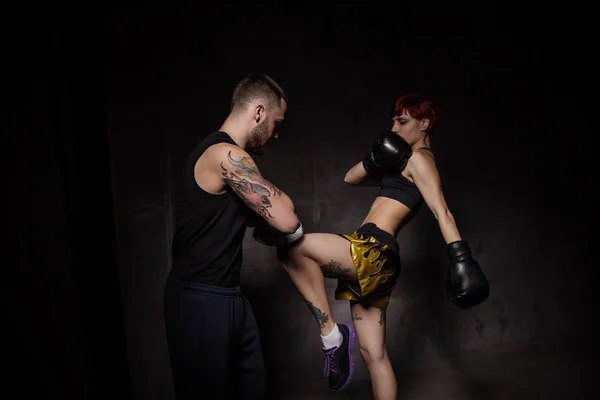 Mujer boxeadora golpeando guantes de entrenamiento sostuvo un entrenador de boxeo — Foto de stock gratis