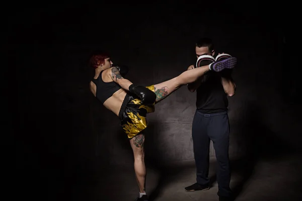 Femeia boxer lovind mănuși de antrenament a ținut un antrenor de box — Fotografie, imagine de stoc
