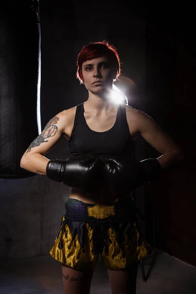 Jovem mulher de boxe no quarto escuro — Fotografia de Stock
