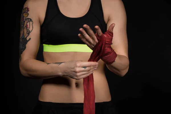 Close-up of a woman wrapping hands with red boxing wraps — Stok Foto