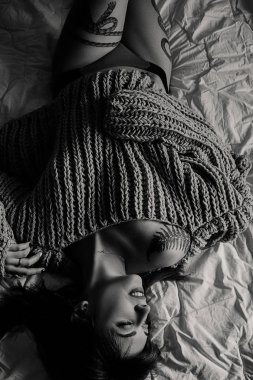 Güzel genç kadın yatakta pembe oversize kazak