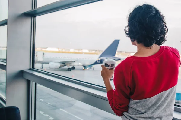 Jeune femme avec tasse de café à l'aéroport — Photo