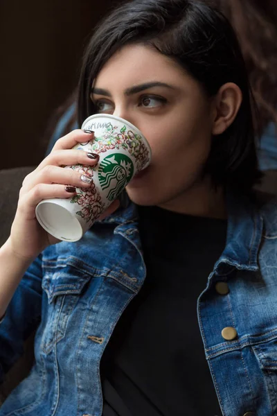 Beautiful young woman drinking coffee at Starbucks cafe in Barcelona — Stock Photo, Image