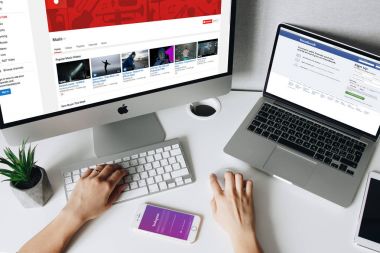 Sosyal medya sitelerinde dizüstü bilgisayar, bilgisayar ve telefon ile arayan kadın