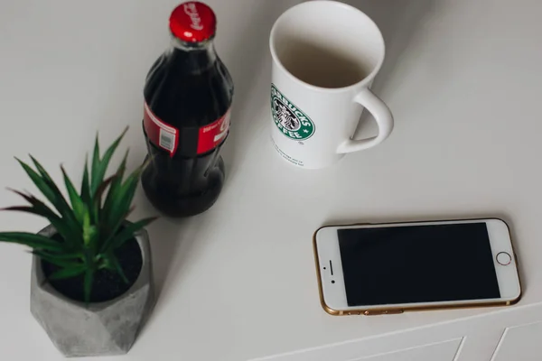 Starbucks Κύπελλο, μπουκάλι Coca Cola και το iphone 7 στο λευκό γραφείο — Φωτογραφία Αρχείου