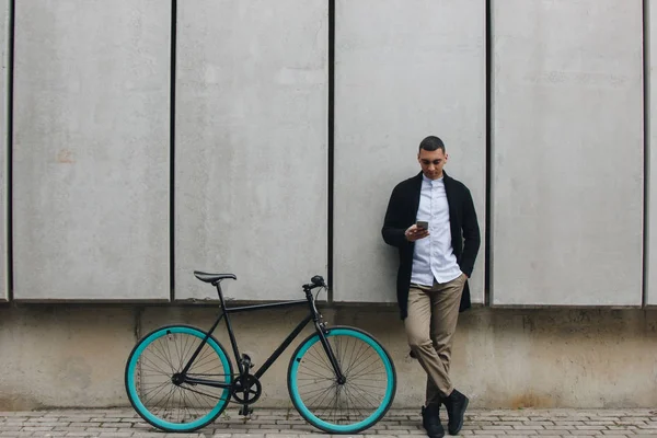 Hombre con teléfono y bicicleta — Foto de Stock