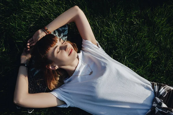 Хипстерская девушка отдыхает на траве — стоковое фото