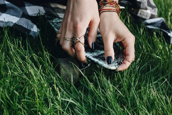 Hands with rings holding skate board